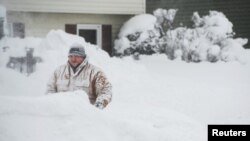 Một người dân dọn tuyết ở trước nhà, Erie, Pennsylvania, 27/12/2017.